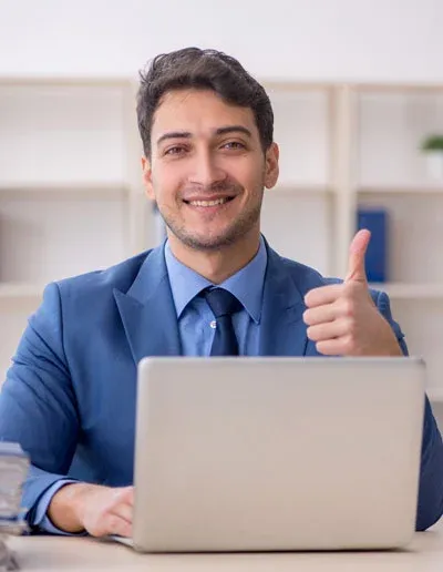 Young man on laptop giving thumbs up